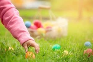 Child picking up an easter egg.
